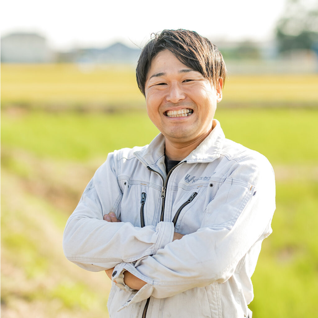 笑顔で腕を組む職人